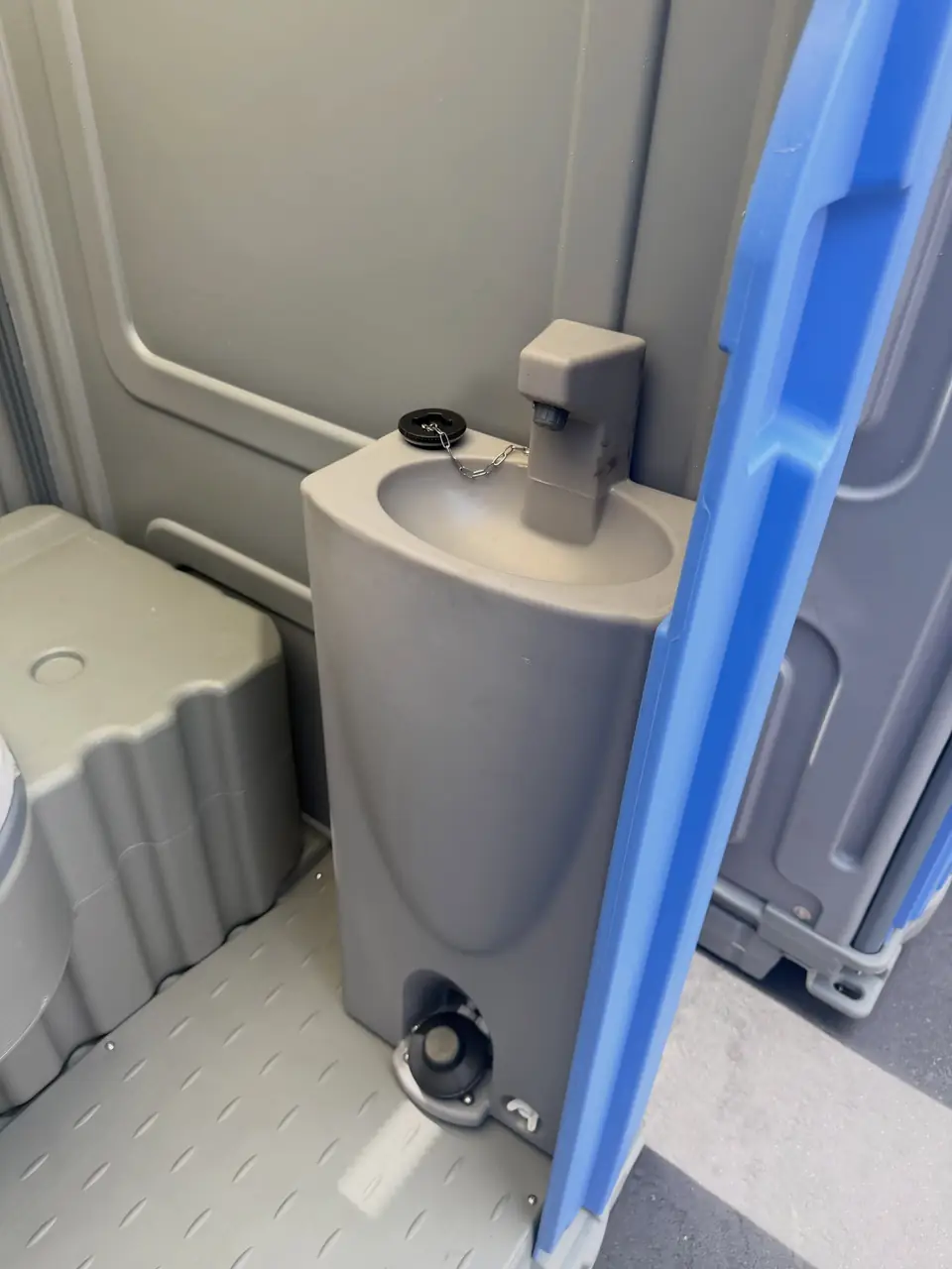 Foot-pump hand sink inside a deluxe porta potty
