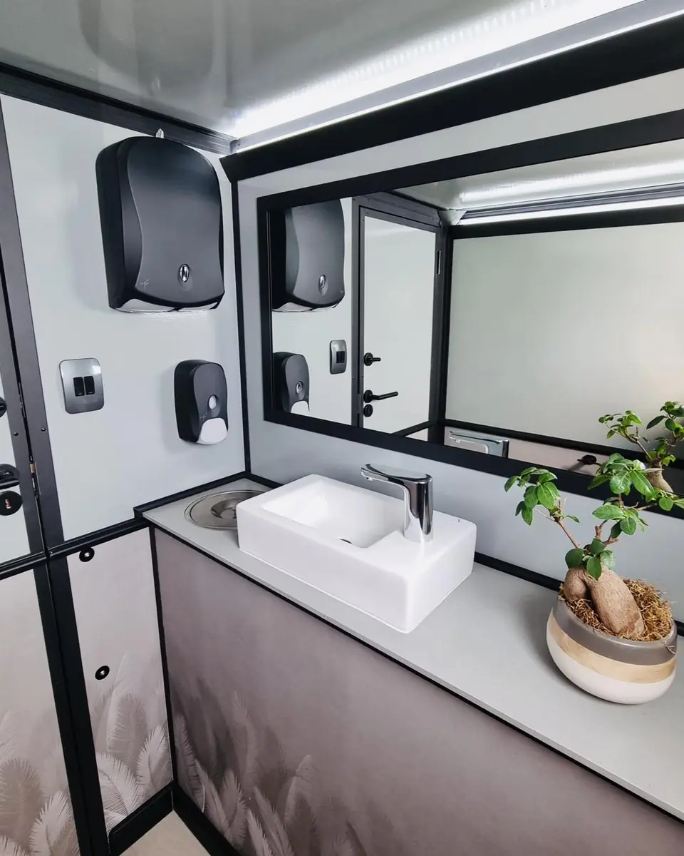 Restroom trailer vanity with mirror, sink and plant