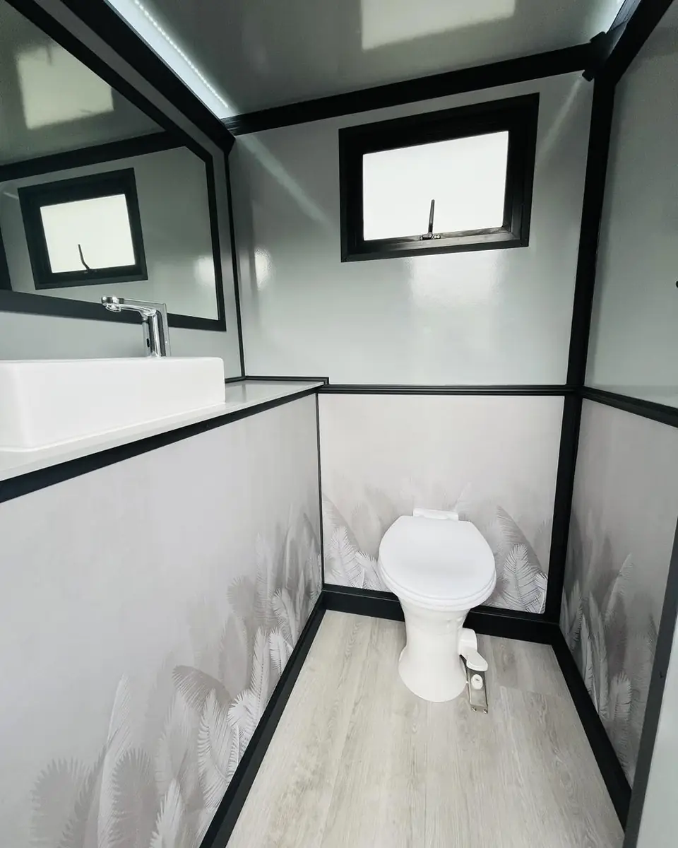 Restroom trailer stall with toilet and window