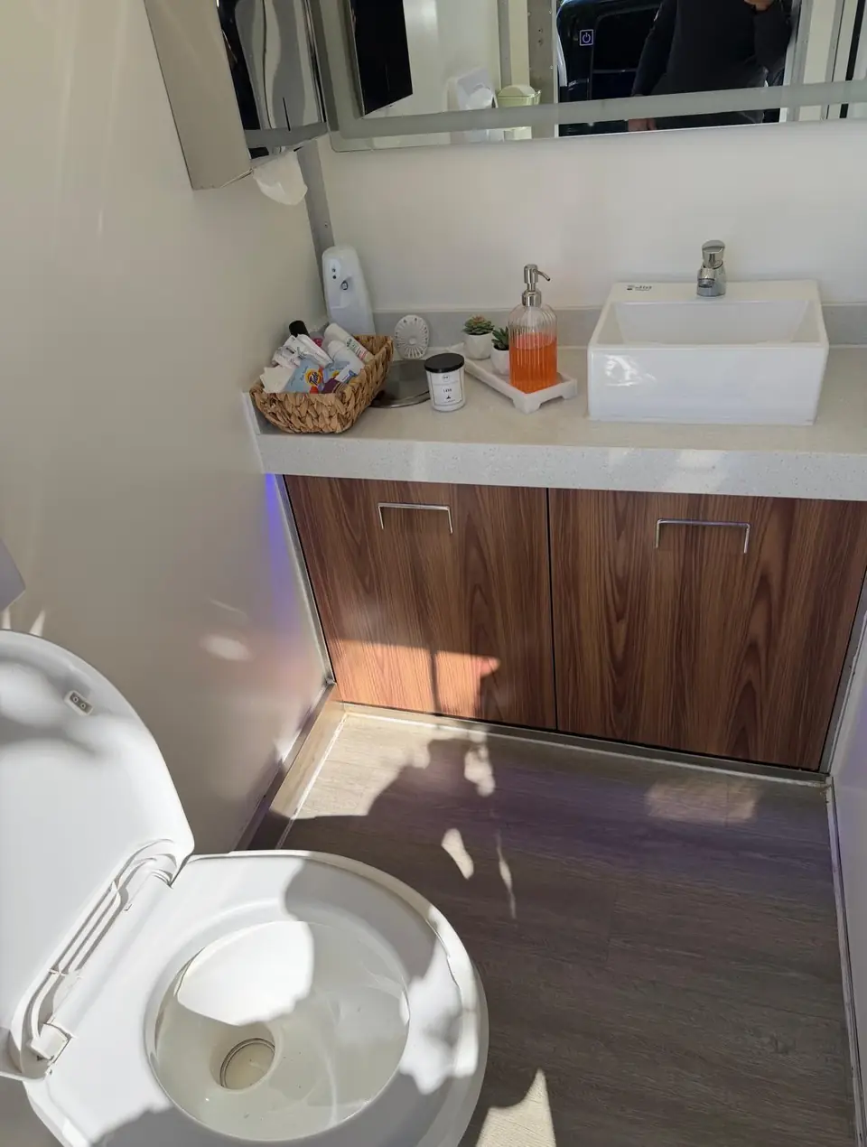 Wood vanity and vessel sink in a restroom trailer